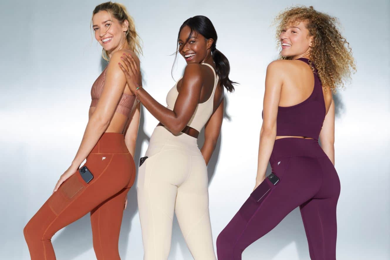 three women in Fabletics outfits - leggings, tank tops, and sports bras