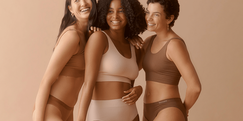 three women in underwear smiling at camera