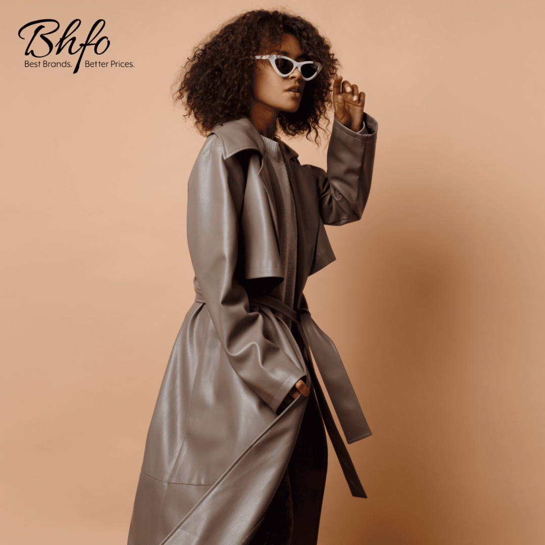 African American woman with natural curly hair in brown leather trench coat and black sunglasses against plain tan background; BHFO logo in top left corner