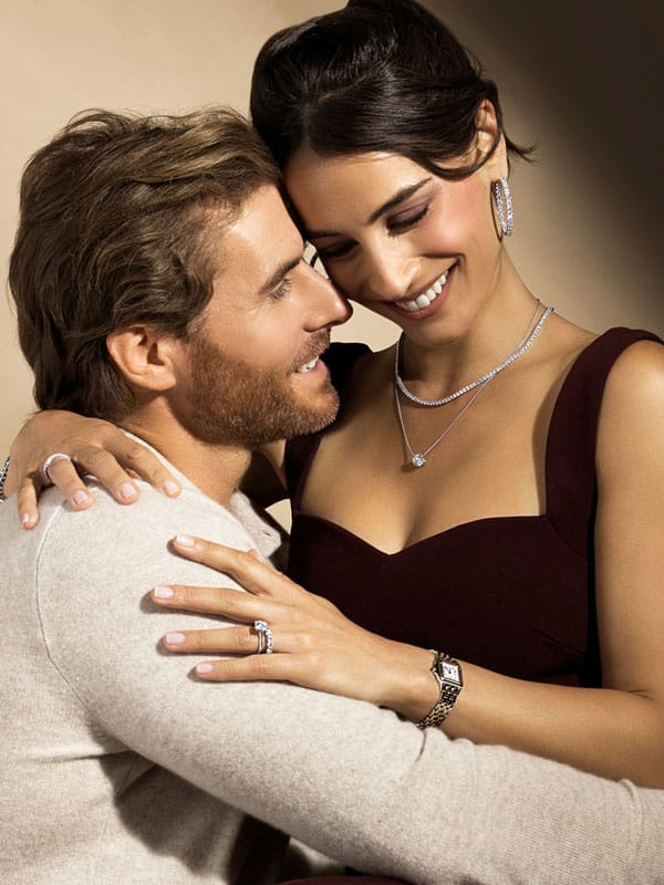 Man and woman hugging wearing fine jewelry pieces