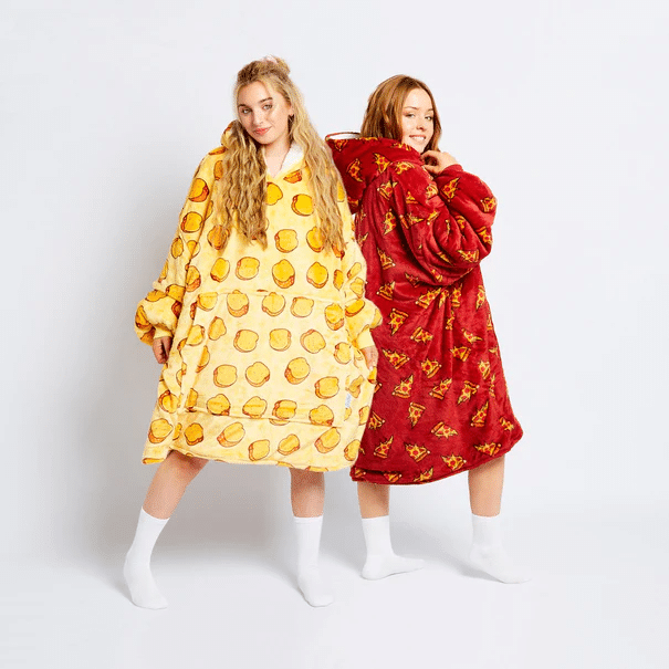 two women in onsies smiling - one yellow , one red