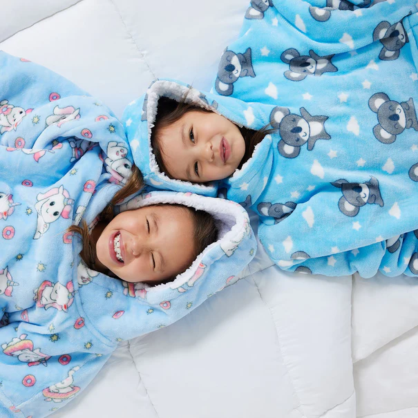 two kids in onsies laying down with the hoods up